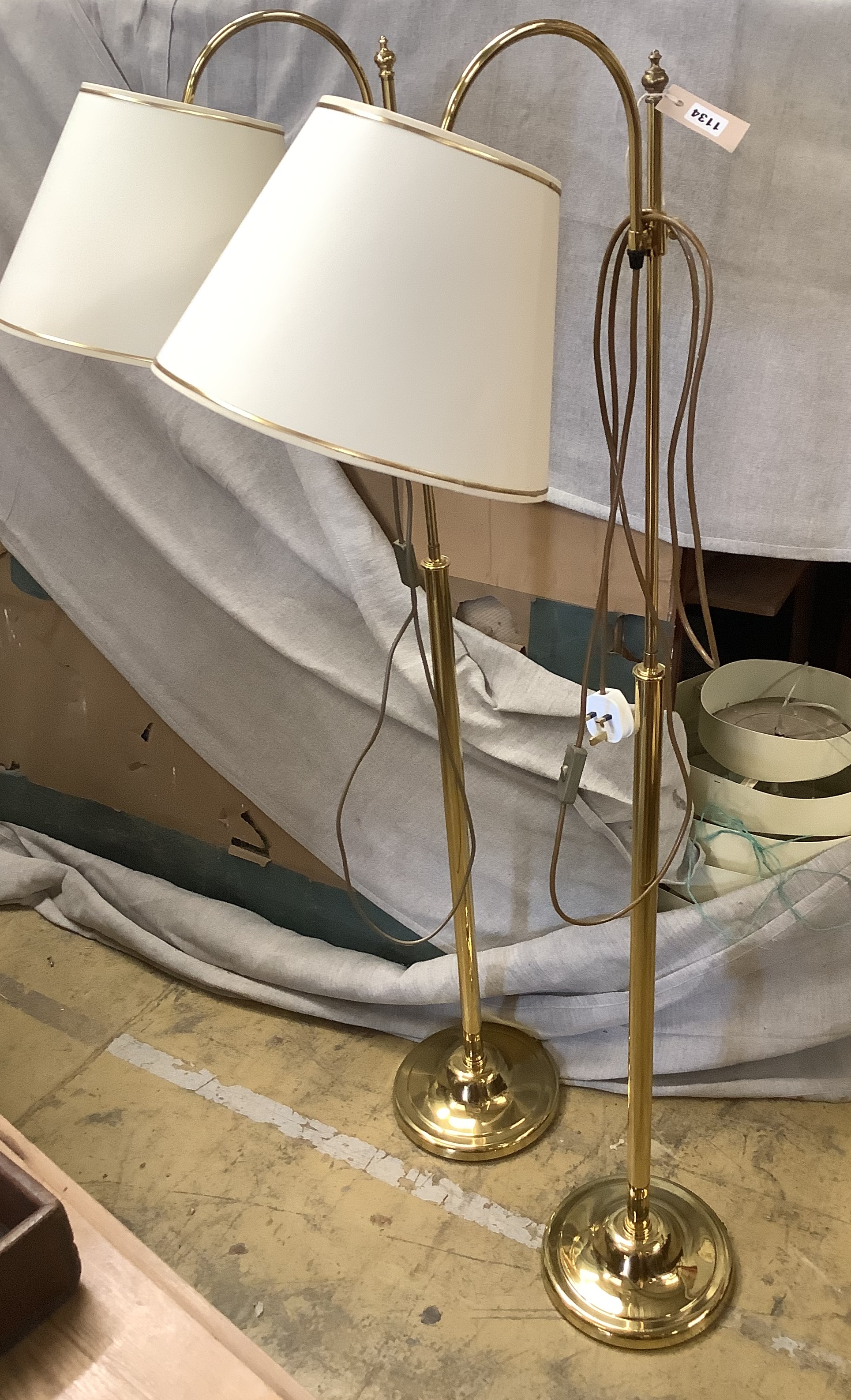 A pair of gold-coloured metal adjustable floor lamps